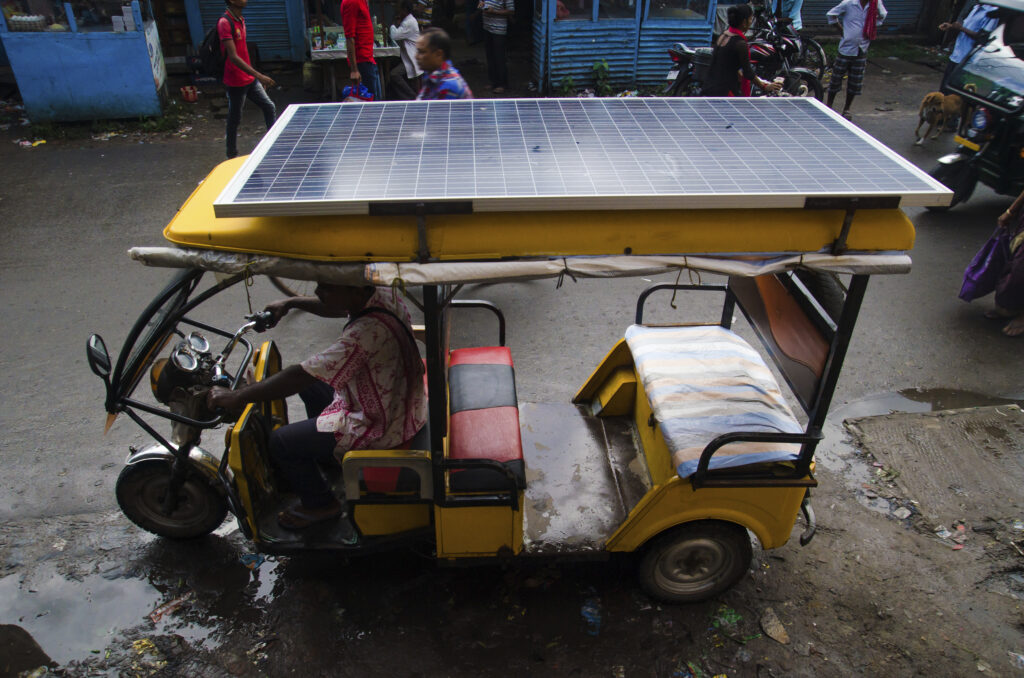 A man drives a solar-charged rikshaw in India