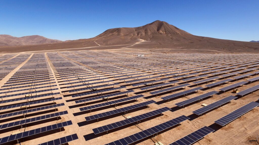 A large array of solar panels in an arid environment.