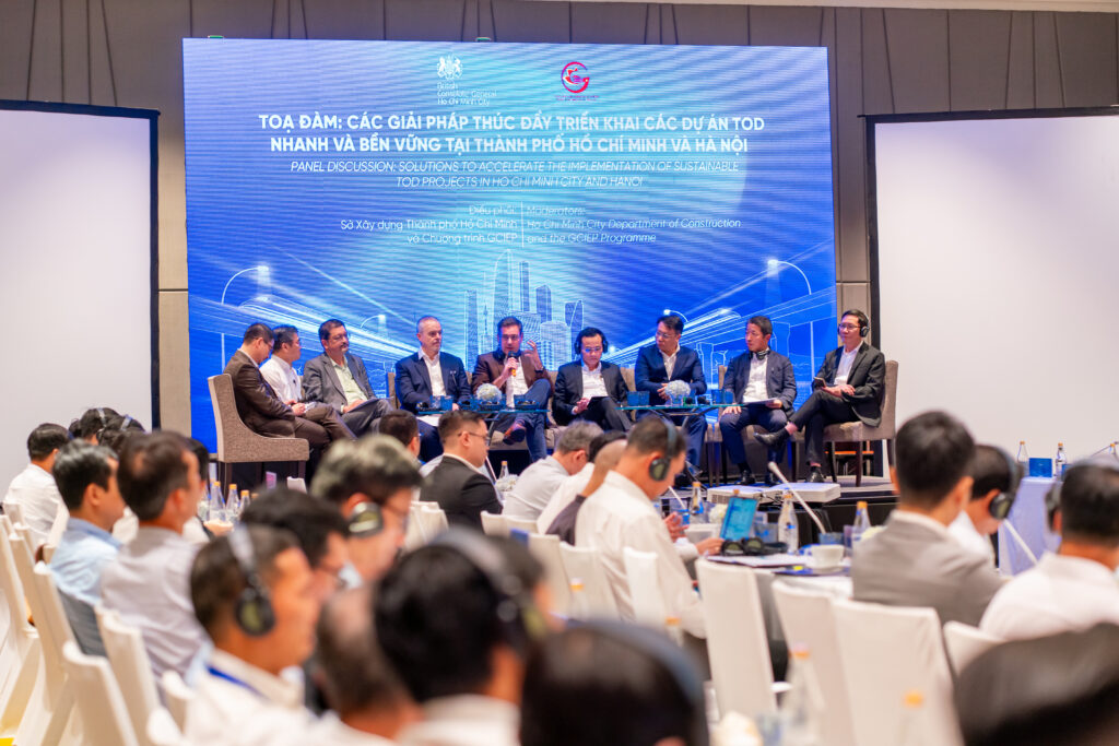 A delegation in Ho Chi Minh City, with 9 speakers on stage in front of a screen.